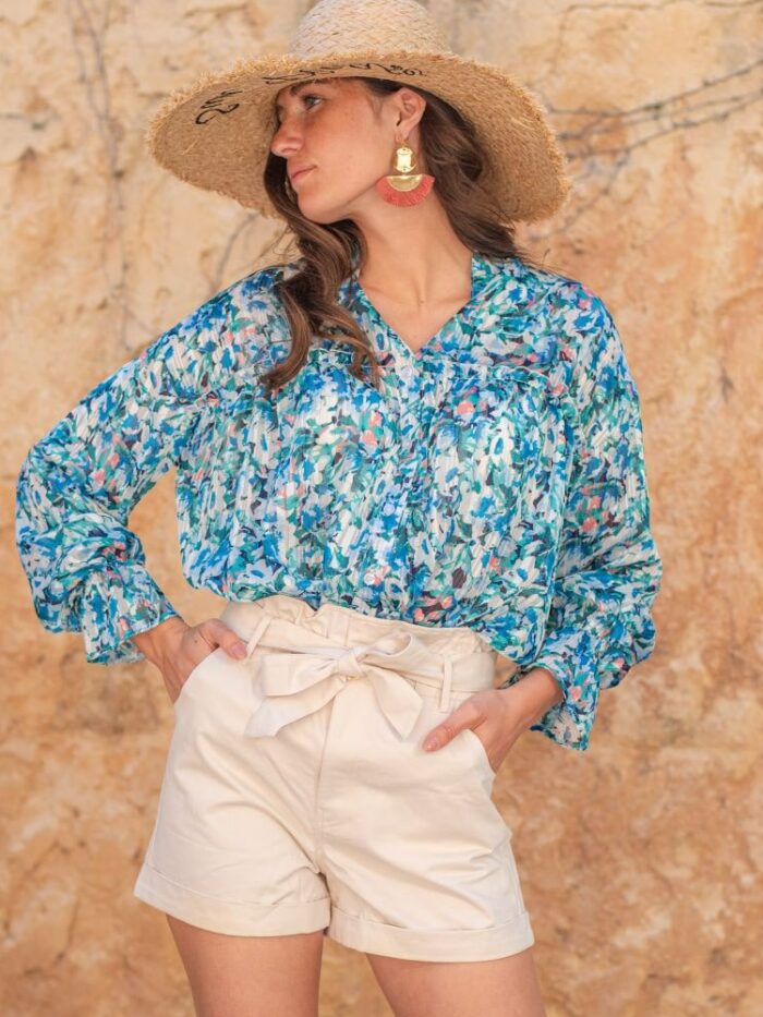 femme portant un look tendance d'été, short paper bag avec chemise bleue et chapeau