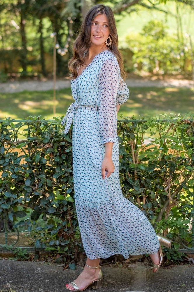femme portant une robe longue d'été à imprimé fleuri bleue